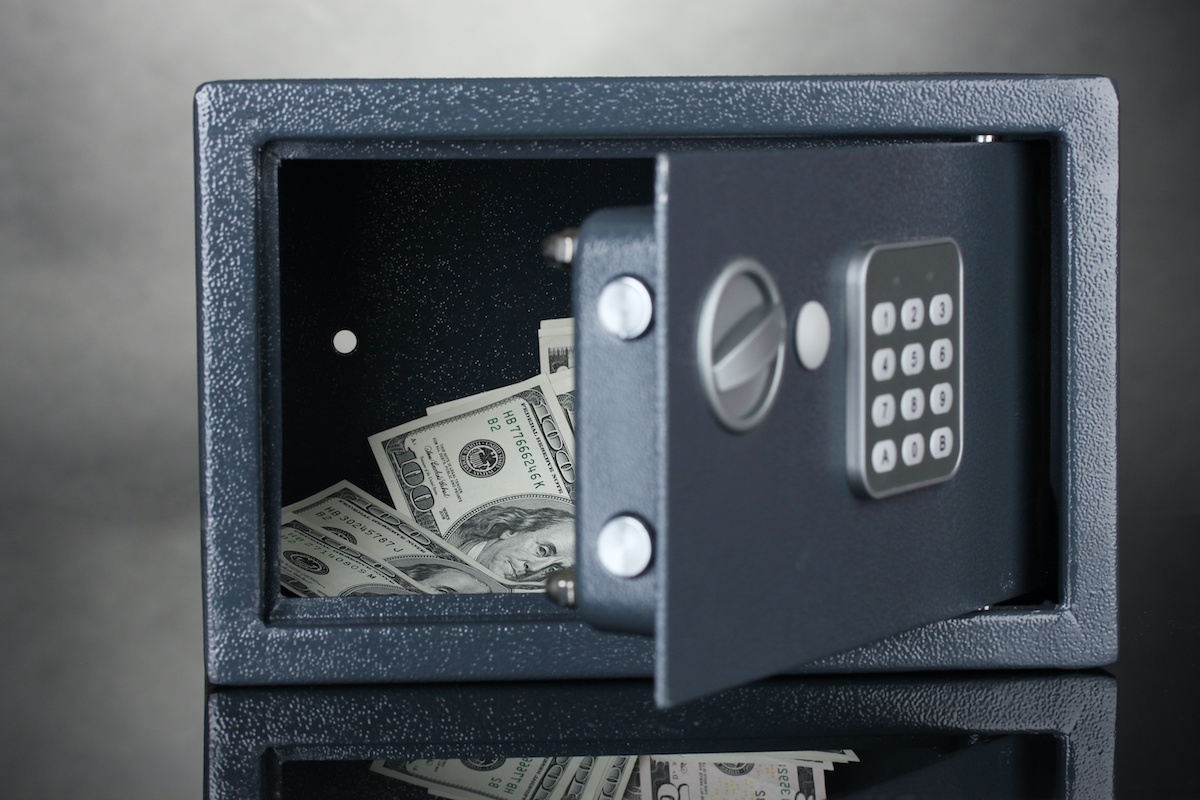 safe with dollars on grey background. safe with dollars on grey background